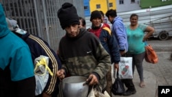 FILE - People wait in line for a free meal provided by the Casa Comunitaria del Fondo soup kitchen in Buenos Aires, Argentina, Nov. 1, 2023. An Argentine study says the country's poverty level reached a 20-year high in January. 