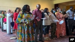 Dozens of people become U.S. citizens during a naturalization ceremony in St. Paul, Minnesota, June 21, 2023. The U.S. citizenship test is being updated and some immigrants and advocates worry the changes will hurt test-takers with lower levels of English proficiency.