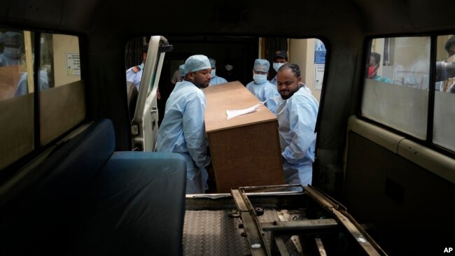 Health care workers load the coffin of a person who was killed in Friday's train accident into an ambulance at a hospital in Bhubaneswar, in the eastern state of Odisha, India, June 5, 2023.