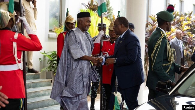 Senegal's President Macky Sall, right, is received by Nigerian Minister of Foreign Affairs Yusuf Tuggar in Abuja, Nigeria, Feb. 24, 2024. Leaders of the Economic Community of West African States met to address a political crisis in the coup-hit region.