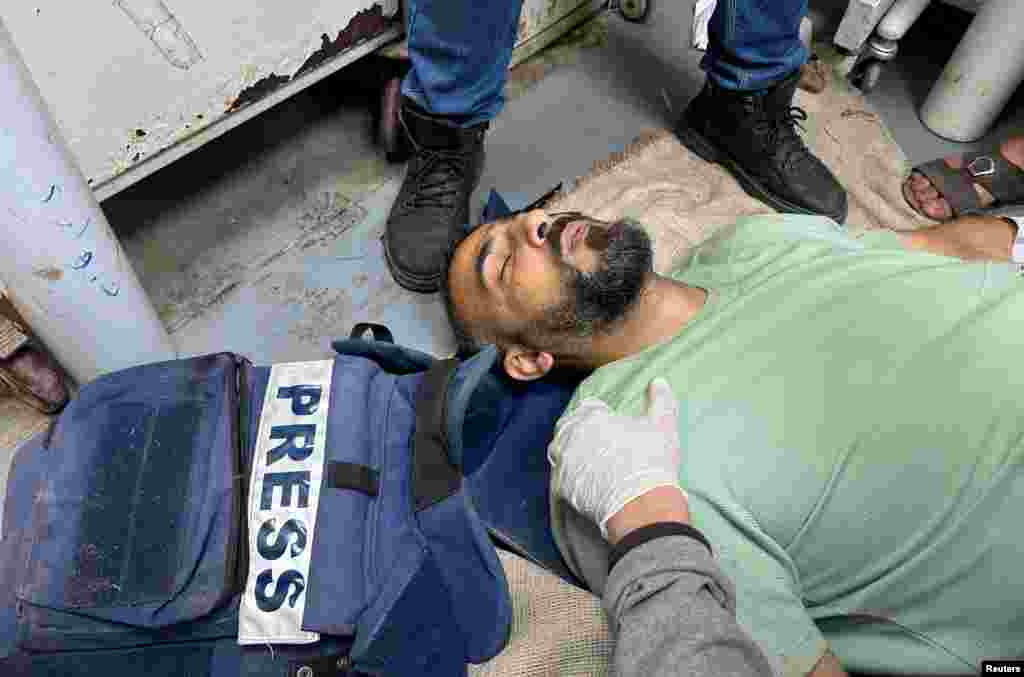 Palestinian journalist Sami Shehada, wounded in an Israeli strike, lies on the floor at Al-Aqsa hospital, amid the ongoing conflict between Israel and Hamas, in Deir Al-Balah in the central Gaza Strip.