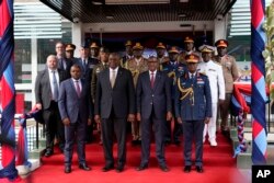 U.S. Defense Secretary Lloyd Austin, center left, his Kenyan counterpart Aden Duale, center right, and others pose for a photo after the signing of a bilateral defense cooperation agreement, in Nairobi, Kenya, Sept. 25, 2023.