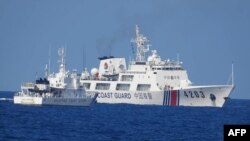 Sebuah kapal Penjaga Pantai China (kanan) diduga memblokir kapal patroli Penjaga Pantai Filipina Malabrigo di dekat Second Thomas Shoal di laut China Selatan yang disengketakan. (Foto: via AFP)