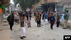 Security personnel and people gather near the site of a bomb explosion at Sibi, in Baluchistan province, Jan. 30, 2024. 