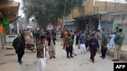 Sejumlah petugas keamanan dan warga berkumpul di dekat lokasi pengeboman di Sibi, provinsi Balochistan, Pakistan, pada 30 Januari 2024. (Foto: AFP)