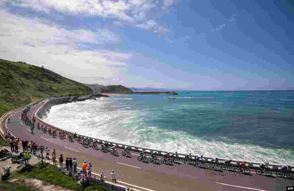 The pack of riders cycles along the Bay of Biscay coastline, near Getaria, in the Basque region of Northern Spain, during the 3rd stage of the 110th edition of the Tour de France cycling race, 193,5 km between Amorebieta-Etxano in Northern Spain and Bayonne in southwestern France, July 3, 2023.