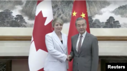 In this image taken from video, Canadian Foreign Minister Melanie Joly, left, shakes hands with Chinese Foreign Minister Wang Yi in Beijing on July 19, 2024. (CCTV via Reuters)