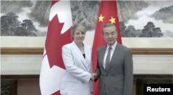 Menteri Luar Negeri Kanada Melanie Joly berjabat tangan dengan Menteri Luar Negeri China Wang Yi di Beijing pada 19 Juli 2024. (CCTV via Reuters)