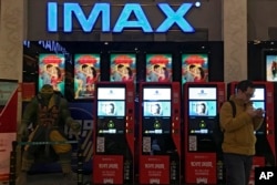 Panel display di sebuah bioskop IMAX di Beijing, China, menayangkan poster proosi film "Crazy Rich Asians" yang tengah diputar di bioskop tersebut, 4 Desember 2018. (AP/Fu Ting)