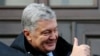FILE - Ukrainian former President Petro Poroshenko gives a thumbs-up as he greets supporters after a court hearing in Kyiv, Ukraine, Jan. 19, 2022. 