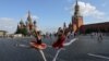 Dua anak perempuan memperagakan tari balet berpose di dekat Katedral St. Basil dan Menara Spasskaya Kremlin di Lapangan Merah di pusat kota Moskow, Rusia. (Reuters)