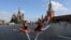 Dua anak perempuan memperagakan tari balet berpose di dekat Katedral St. Basil dan Menara Spasskaya Kremlin di Lapangan Merah di pusat kota Moskow, Rusia. (Reuters)