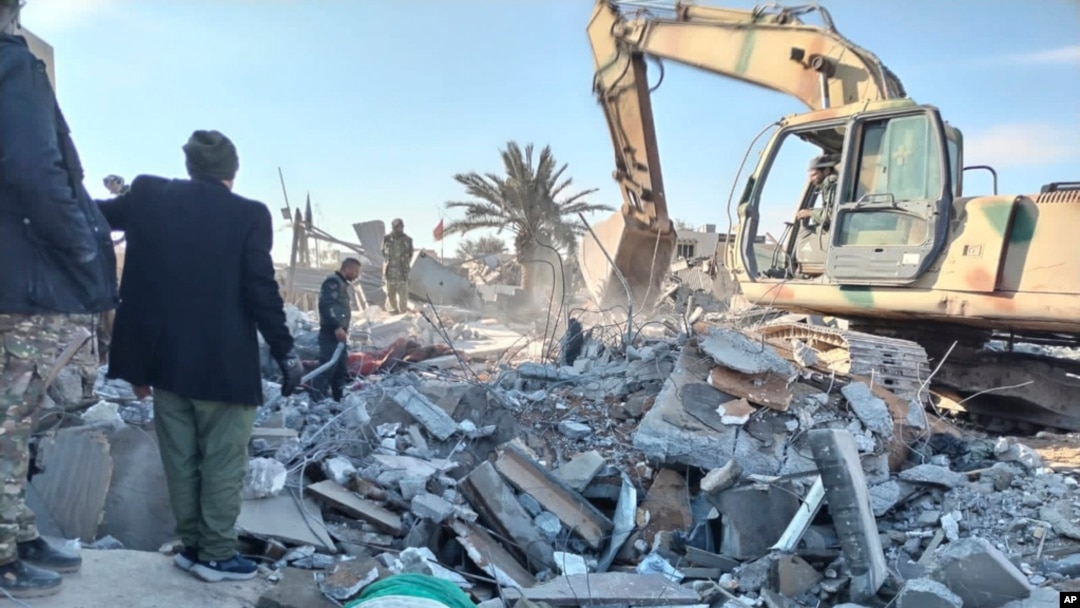 Members of Iraqi Shiite Popular Mobilization Forces clean the rubble after a US airstrike in al-Qaim, Iraq, Feb. 3, 2024. 