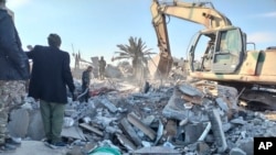 Members of Iraqi Shiite Popular Mobilization Forces clean the rubble after a US airstrike in al-Qaim, Iraq, Feb. 3, 2024. 