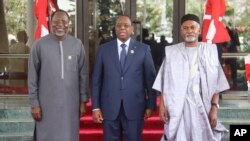 Omar Touray, president of the ECOWAS Commission, left, Senegal's President Macky Sall, center and Nigeria Minister of Foreign Affairs, Yusuf Tuggar pose for a photo, ahead of the ECOWAS meeting in Abuja, Nigeria on Saturday, February 24, 2024.