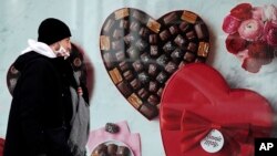 FILE - A man passes a Fannie May chocolate shop in downtown Chicago on Valentine's Day, Feb. 14, 2021.