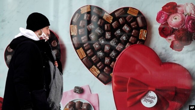 FILE - A man passes a Fannie May chocolate shop in downtown Chicago on Valentine's Day, Feb. 14, 2021.