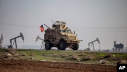 FILE - A US military vehicle on a patrol in the countryside near the town of Qamishli, Syria, Dec. 4, 2022.