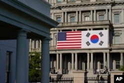American and South Korean flags hang from the Eisenhower Executive Office Building on the White House campus, in Washington, April 21, 2023.