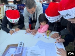 在洛杉矶中国领事馆门前马路对面的桌子上，人们通过写明信片送祝福的方式，表达对牛腾宇及他的母亲，以及在中国受到政府关押的政治犯的关心。（美国之音 张木林）