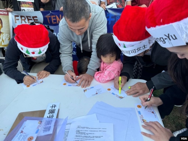 在洛杉矶中国领事馆门前马路对面的桌子上，人们通过写明信片送祝福的方式，表达对牛腾宇及他的母亲，以及在中国受到政府关押的政治犯的关心。（2023年12月24日）