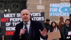 FILE - British lawmaker Iain Duncan Smith joins activists and community members as they hold a small protest outside the British Foreign Office in central London, Feb. 13, 2023. 