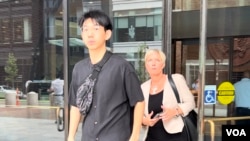 Xiaolei Wu, who was indicted on charges of stalking and threatening a pro-democracy activist at his college in Boston, walks out of federal court in Boston with his lawyer, Jessica Hedges, after a pre-trial conference, July 27, 2023. (Hai Lun/VOA)