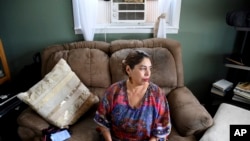 Lucy Molina sits in her living room in Commerce City, Colo., July 25, 2023. Without central air conditioning, her Denver area home has reached 107 degrees Fahrenheit (41.7 Celsius).