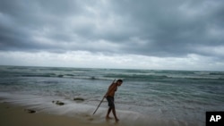 A man practices acrobatics with a pole on the beach in the aftermath by Hurricane Beryl in Tulum, Mexico, July 5, 2024. 