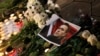 A portrait of Russian opposition leader Alexey Navalny is placed next to candles and flowers, as people attend a memorial event for Navalny, in front of the Russian embassy in Sofia, Bulgaria, Feb. 16, 2024. 