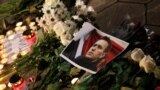 A portrait of Russian opposition leader Alexey Navalny is placed next to candles and flowers, as people attend a memorial event for Navalny, in front of the Russian embassy in Sofia, Bulgaria, Feb. 16, 2024. 
