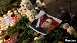 A portrait of Russian opposition leader Alexey Navalny is placed next to candles and flowers as people attend a memorial event for Navalny in front of the Russian embassy in Sofia, Bulgaria, Feb. 16, 2024. 