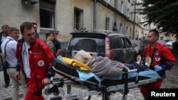 Paramedics carry a person from a residential building hit by a Russian missile strike in Lviv, Ukraine, July 6, 2023.