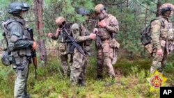 FILE - In this image taken from video released by Belarus' Defense Ministry on July 20, 2023, Belarusian soldiers and mercenary fighters from Wagner private military company attend the weeklong maneuvers conducted at a firing range near the border city of Brest, Belarus. 