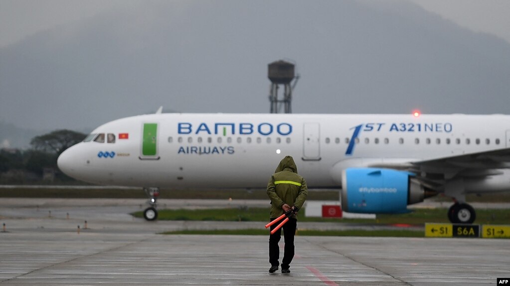 Một nhân viên mặt đất hướng dẫn cho máy bay của Bamboo Airways trên đường băng ở sân bay quốc tế Nội Bài, Hà Nội, trong ngày hoạt động đầu tiên của hãng hôm 16/1/2019.