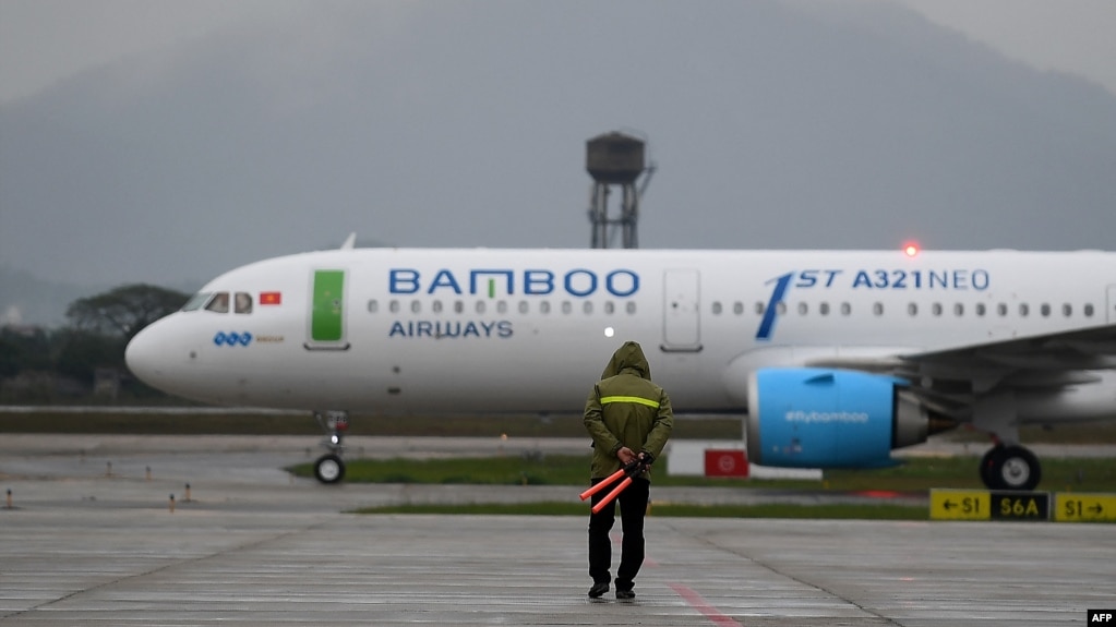 Một nhân viên mặt đất hướng dẫn cho máy bay của Bamboo Airways trên đường băng ở sân bay quốc tế Nội Bài, Hà Nội, trong ngày hoạt động đầu tiên của hãng hôm 16/1/2019.