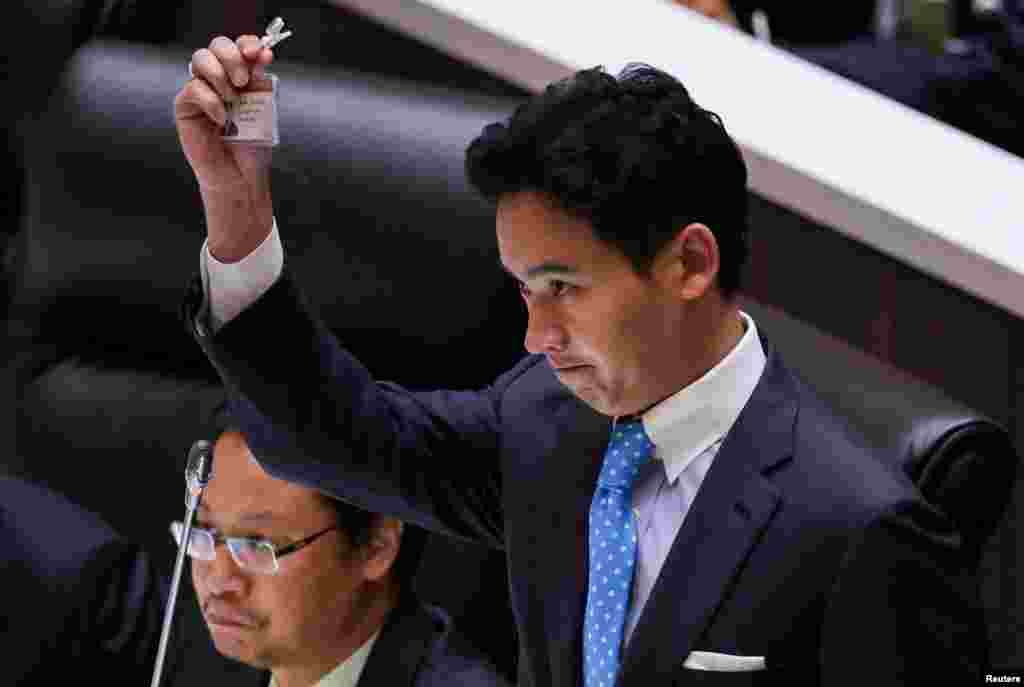 Pita Limjaroenrat, leader of the Move Forward Party, holds up his ID card at Parliament after Thailand&#39;s Constitutional Court ordered his temporary suspension from the Parliament, on the day of the second vote for a new prime minister, in Bangkok.