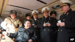 In this photo provided by the North Korean government, North Korean leader Kim Jong Un, front left, provides direction as it conducts a test firing of what it says are surface-to-sea missiles in North Korea, Feb. 14, 2024. 