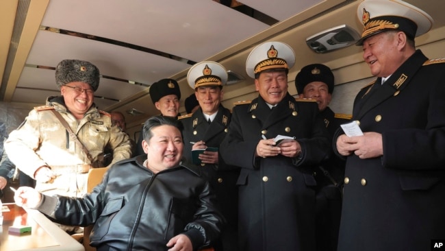 In this photo provided by the North Korean government, North Korean leader Kim Jong Un, front left, provides direction as it conducts a test firing of what it says are surface-to-sea missiles in North Korea, Feb. 14, 2024.