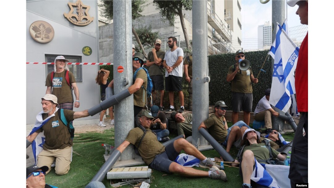 People chain themselves together in front of the Ministry of Defense on the 'Day of National Resistance' in protest against Israeli Prime Minister Benjamin Netanyahu's judicial overhaul, in Tel Aviv, July 18, 2023.