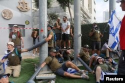 People chain themselves together in front of the Ministry of Defense on the 'Day of National Resistance' in protest against Israeli Prime Minister Benjamin Netanyahu's judicial overhaul, in Tel Aviv, July 18, 2023.