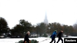 A family pulls&nbsp; a Christmas tree on a sledge through the village of Keele, Staffordshire, Britain.