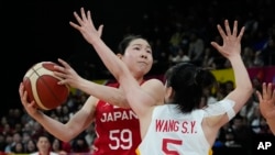 China's Wang Siyu attempts too block a shot from Japan's Anri Hoshi, left, during the Asia Cup women's basketball final in Sydney, Australia, July 2, 2023.