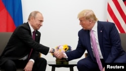 TƯ LIỆU - Tổng thống Nga Vladimir Putin và Tổng thống Mỹ Donald Trump bắt tay trong cuộc gặp song phương tại hội nghị thượng đỉnh các nhà lãnh đạo G20 ở Osaka, Nhật Bản, ngày 28 tháng 6 năm 2019.
