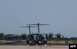 Dua pesawat militer Airbus A400M dari Bundeswehr Angkatan Bersenjata Jerman mendekat pada latihan militer "Air Defender 2023" di pangkalan udara militer di Wunstorf, Jerman utara, 12 Juni 2023. (Ronny Hartmann / AFP)