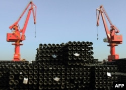 File - On December 1, 2015, steel pipes were loaded for export to various countries at a port in Lianyungang, Jiangsu Province, eastern China.