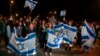 Supporters hold flags as Israeli hostages arrive in a vehicle at Ofakim army base in southern Israel early on Nov. 30, 2023, after being freed from the Gaza Strip following the Oct. 7 attacks in Israel by the Palestinian militant group Hamas. 