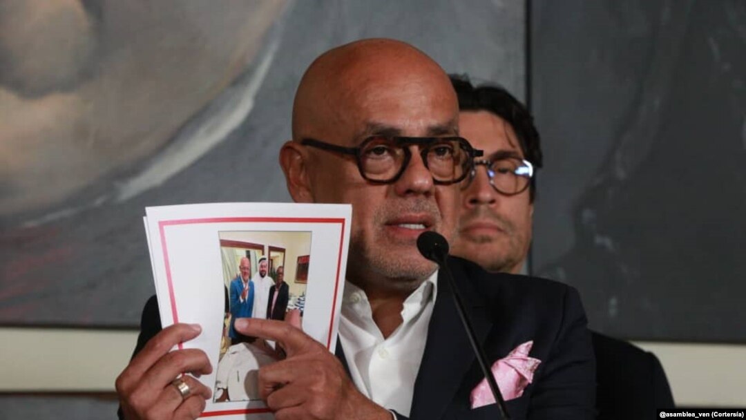 Jorge Rodríguez, presidente del Parlamento de mayoría oficialista de Venezuela muestra una fotografía en la que se le ve junto a Brian Nichols y el facilitador de Qatar durante un proceso directo de negociaciones.