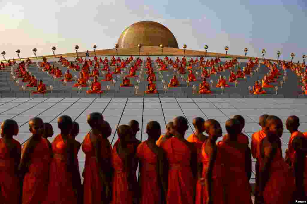 Buddhist monks pray at the Wat Phra Dhammakaya temple during a ceremony commemorating Makha Bucha Day in Pathum Thani province outside Bangkok, Thailand, Feb. 24, 2024.