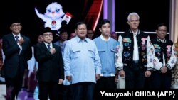 Ketiga pasangan Capres dan Cawapres berpegangan tangan dan berpose bersama usai debat terakhir di Jakarta Convention Center di Jakarta, 4 Februari 2024. (Foto: Yasuyoshi CHIBA/AFP)